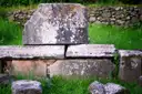 Old carved stone blocks in the grass beside the Appian Way
