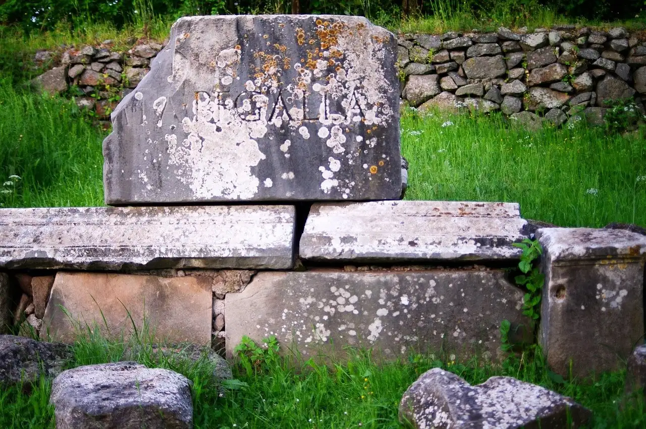 Old carved stone blocks in the grass beside the Appian Way