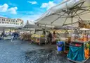 Market stalls under white umbrellas on Campo de' Fiori in Rome