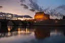 Castel Sant'Angelo lit at dusk, reflected in the Tiber