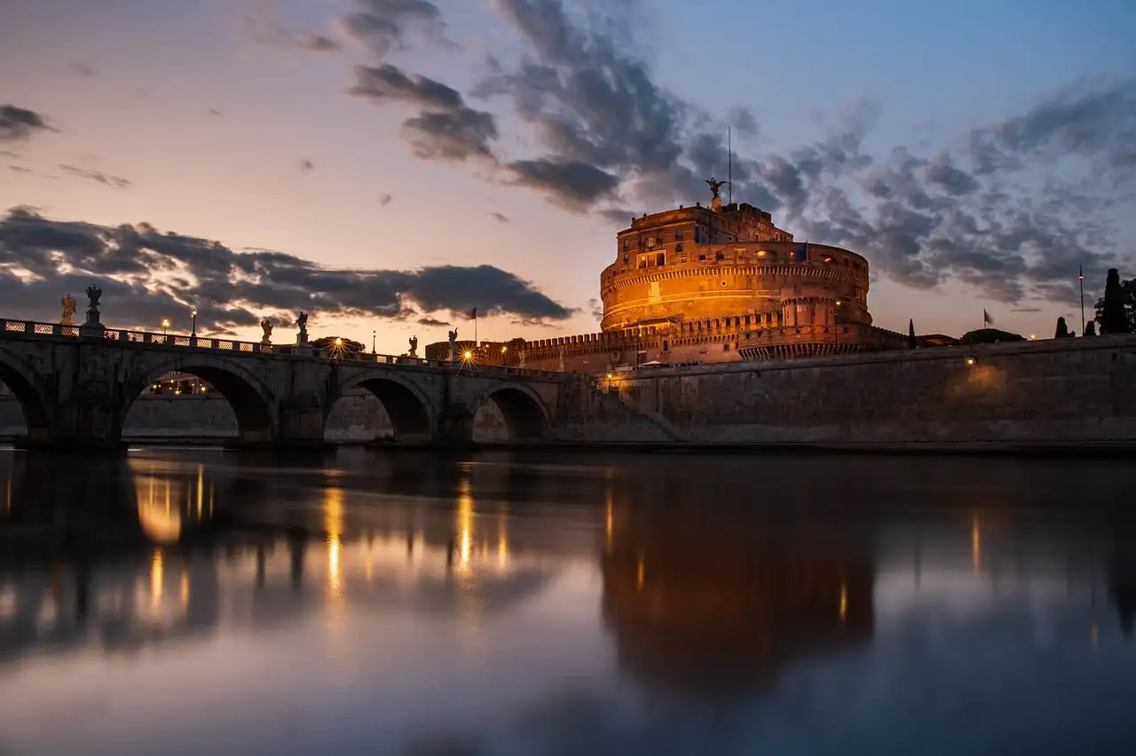 Castel Sant'Angelo lit at dusk, reflected in the Tiber