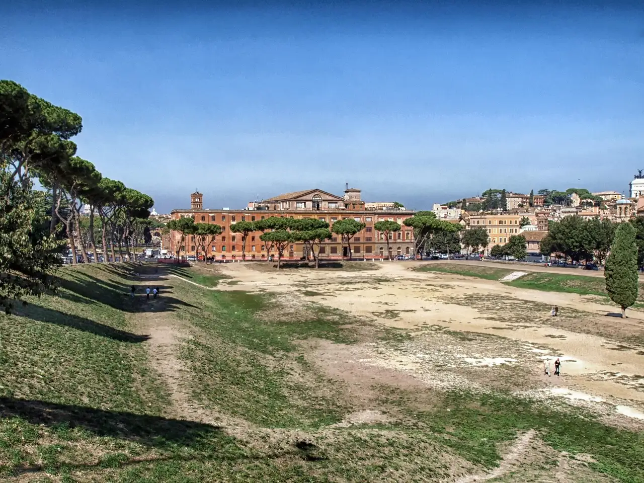 The long grassy track of the Circus Maximus, with trees and buildings beyond