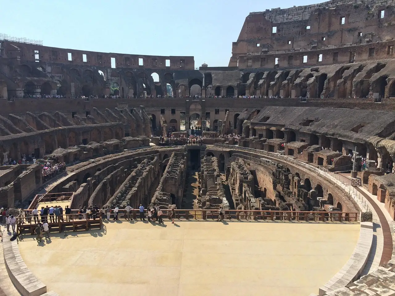 The arena floor platform inside the Colosseum, with the old chambers beyond it