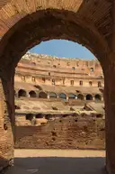 The Colosseum interior seen through a brick archway