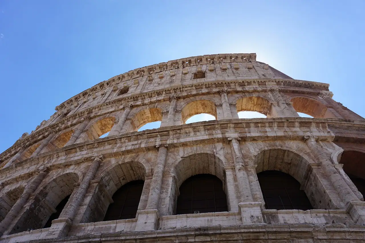 The arches of the Colosseum outer wall against a blue sky