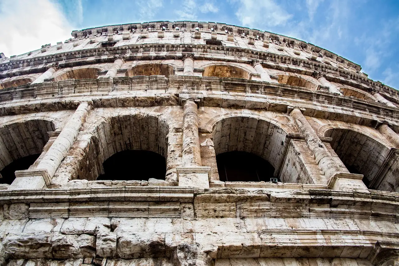 The upper arches of the Colosseum against a blue sky