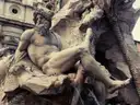 A marble river god on the Fountain of the Four Rivers in Piazza Navona