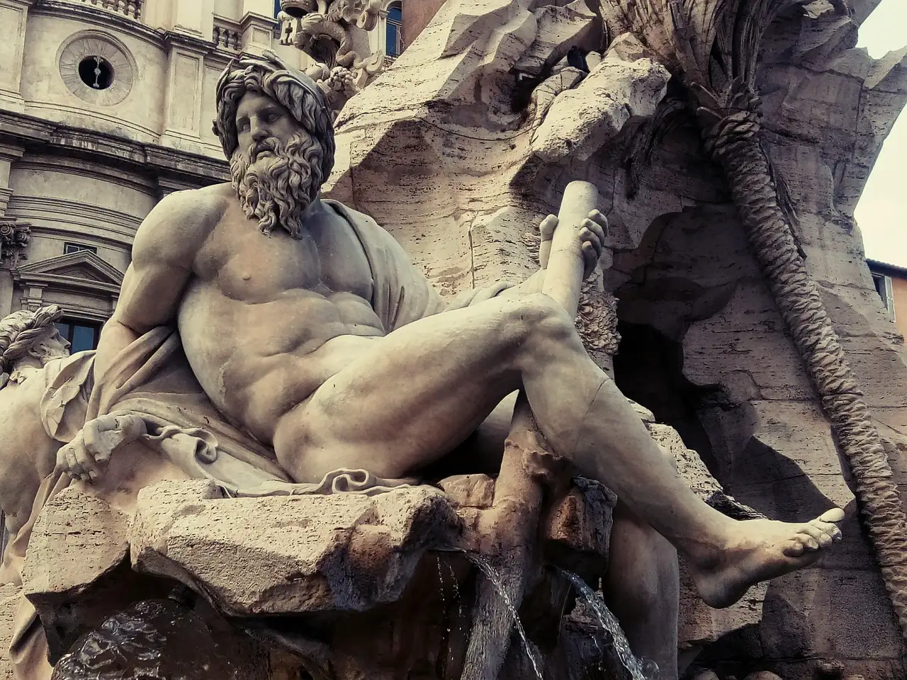 A marble river god on the Fountain of the Four Rivers in Piazza Navona