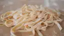 Fresh fettuccine on a board dusted with flour