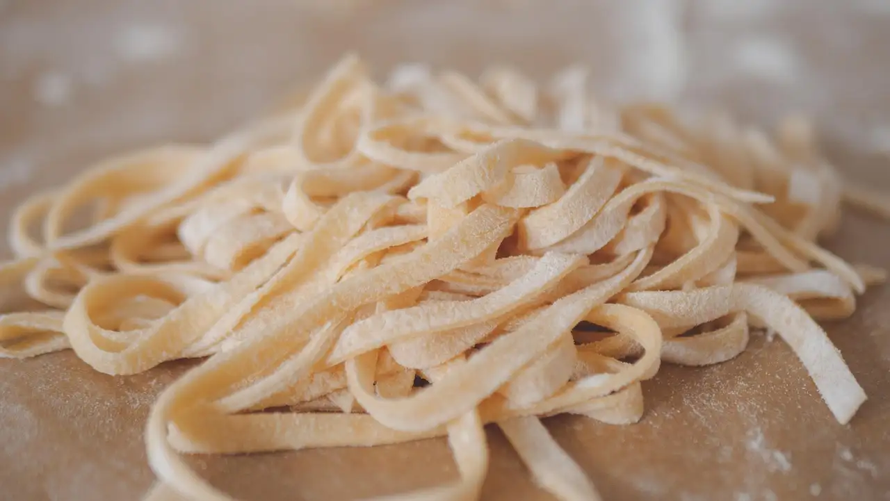 Fresh fettuccine on a board dusted with flour