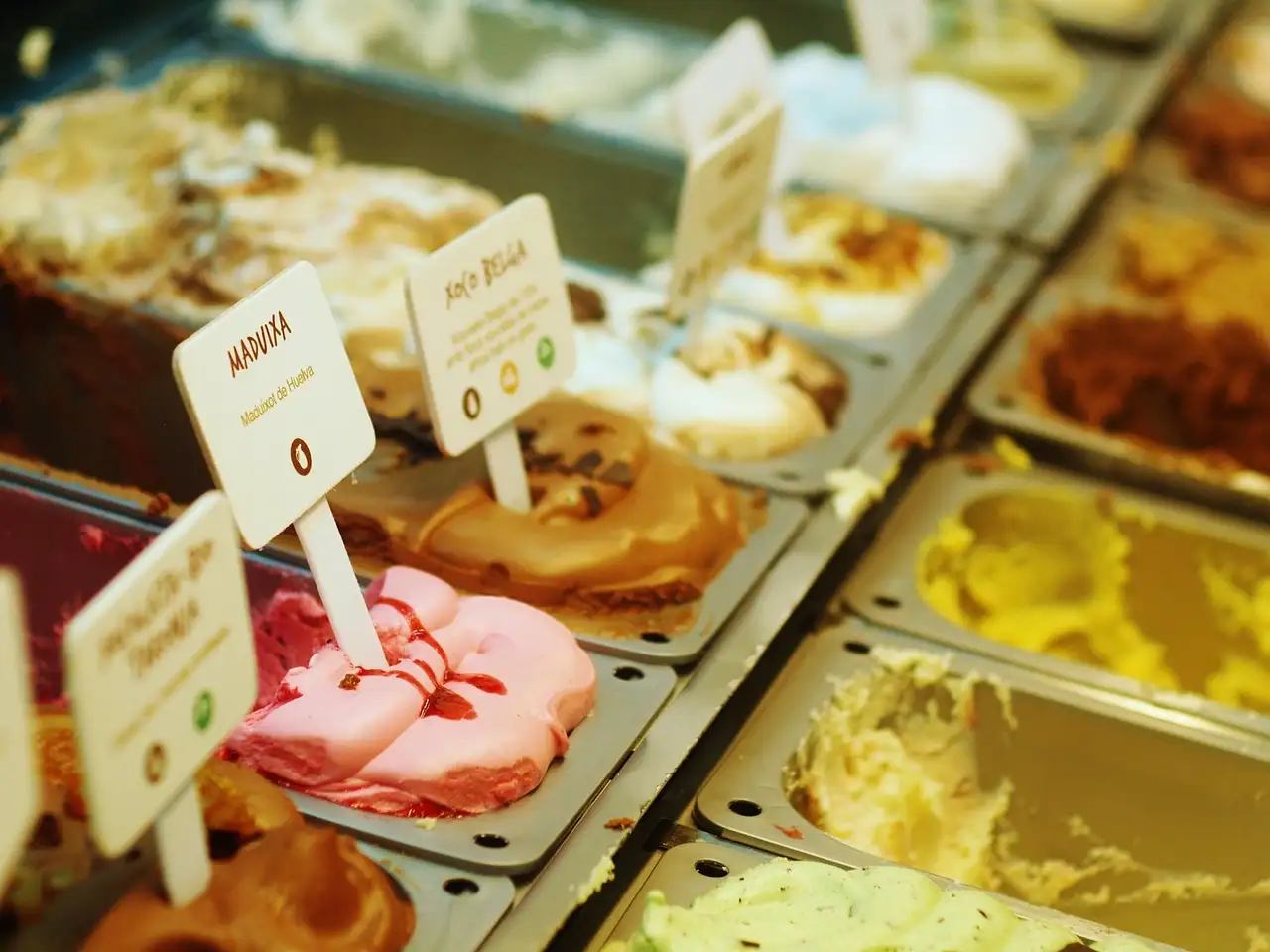 Tubs of gelato in a shop counter, each with a flavor tag