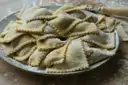 Homemade ravioli on a dark plate
