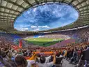 The Stadio Olimpico in Rome during a football match, with fans holding scarves in the stands