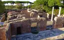 Brick ruins of Roman baths at Ostia Antica, with a black-and-white mosaic floor