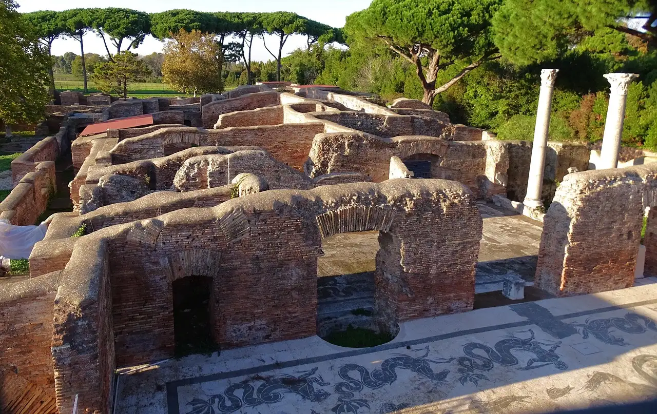 Brick ruins of Roman baths at Ostia Antica, with a black-and-white mosaic floor