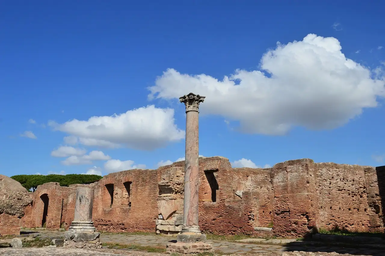 A lone column and brick walls at Ostia Antica under a blue sky