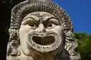 A large stone theatre mask with an open mouth at Ostia Antica