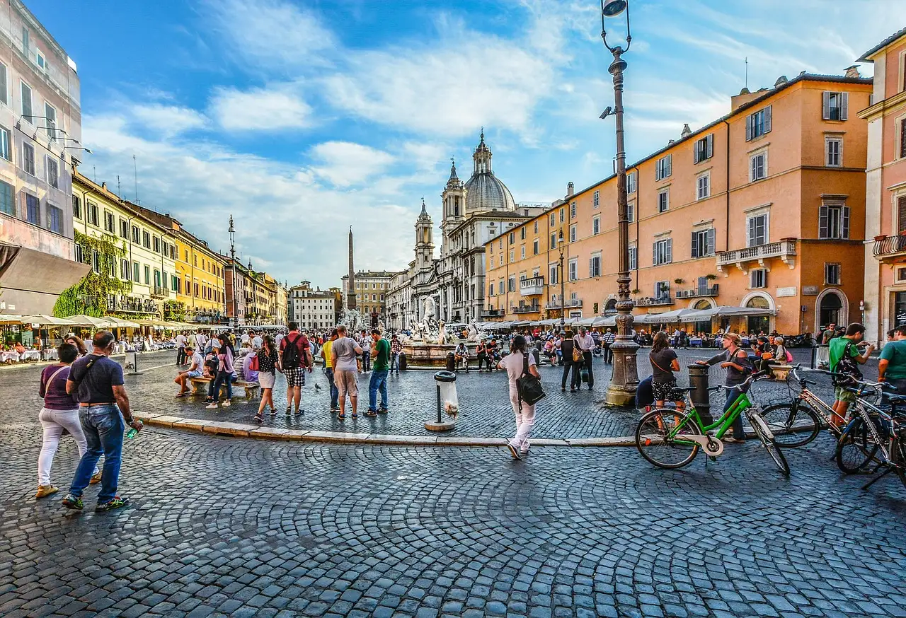 Bicycles parked on the cobbles of Piazza Navona, with a church dome behind