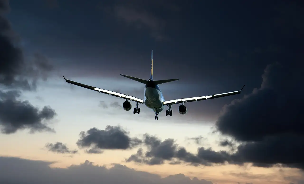 A passenger plane coming in to land under dark clouds