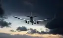 A passenger plane coming in to land under dark clouds