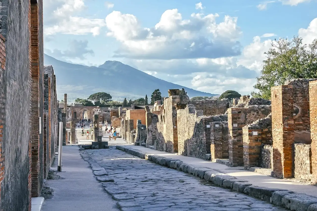 An old paved street in Pompeii with Mount Vesuvius behind it