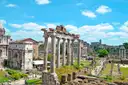 Old temple columns standing in the Roman Forum under a blue sky