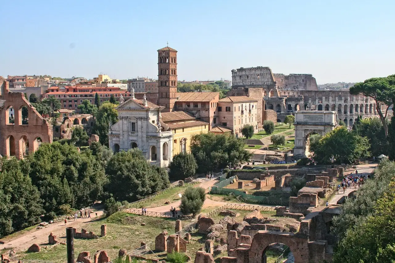 The Roman Forum with ruins and umbrella pines, and the Colosseum in the distance