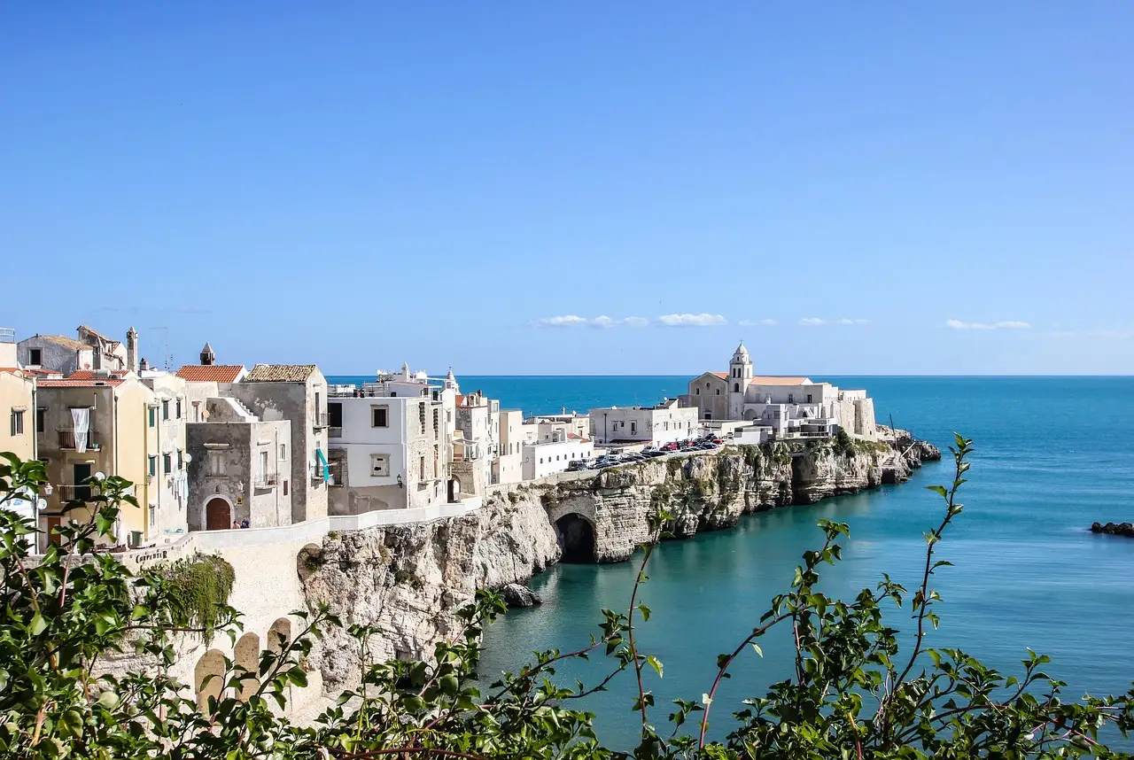 A white clifftop town above a blue sea on the coast of Puglia in southern Italy