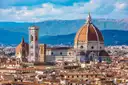 View over Florence rooftops to the cathedral dome and bell tower, with hills behind