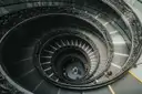 Looking down a spiral staircase with a double ornate railing