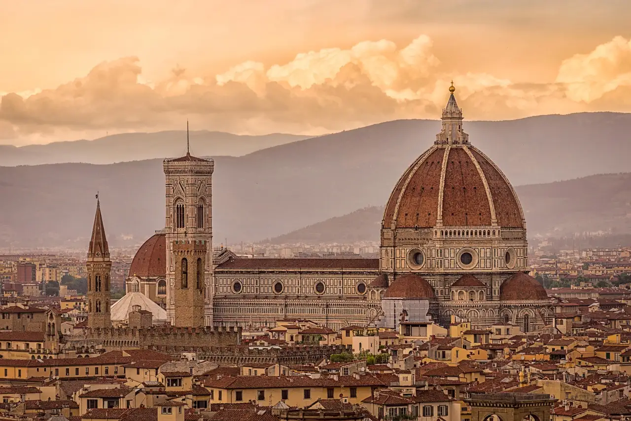 Florence cathedral dome and bell tower over the rooftops in warm evening light