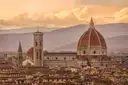 Florence cathedral dome and bell tower over the rooftops in warm evening light