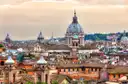 Rome rooftops and church domes in warm evening light