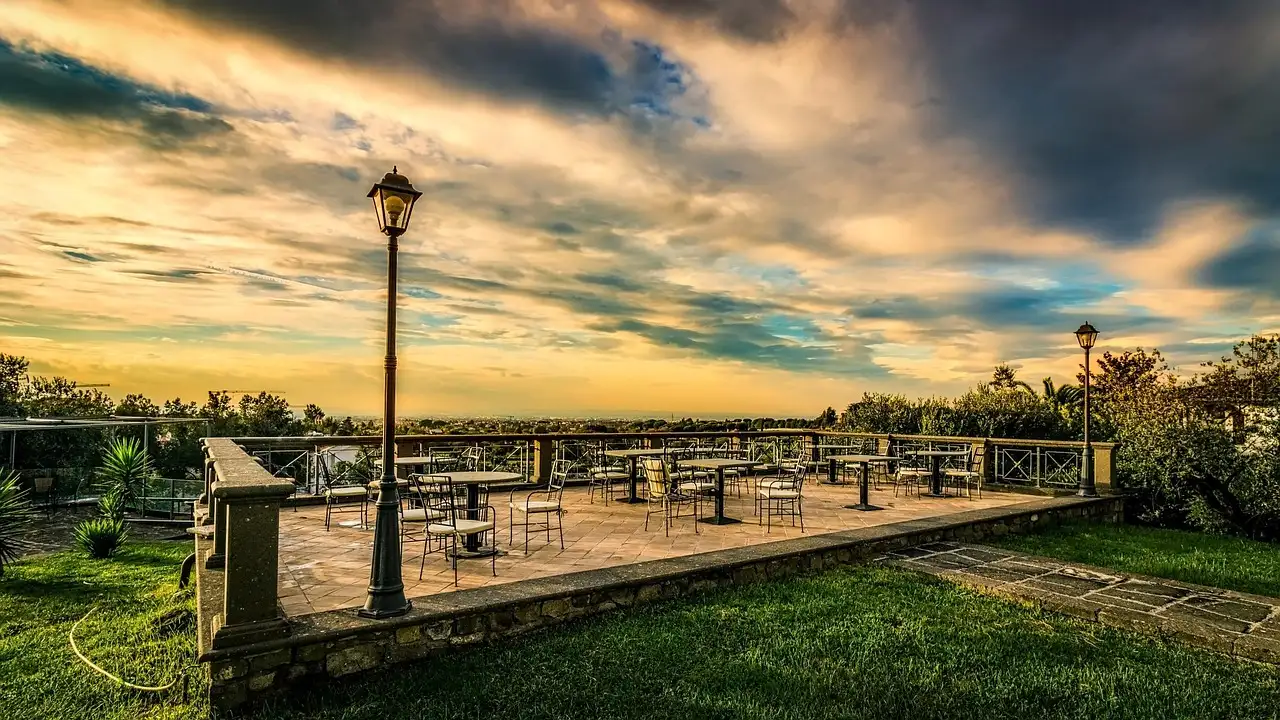An empty viewing terrace with a street lamp above Rome at sunset