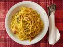 A plate of spaghetti carbonara on a red checked cloth