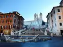 The Spanish Steps and the Barcaccia fountain in Rome under a clear blue sky