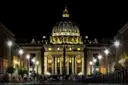 St. Peter's Basilica lit up at night, seen down the street