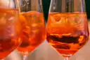 Three glasses of orange spritz cocktails side by side
