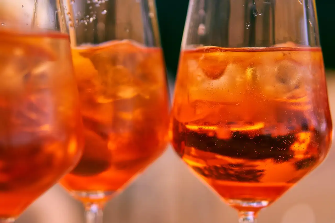 Three glasses of orange spritz cocktails side by side