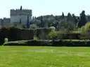 The round stone Tomb of Cecilia Metella on the Appian Way, behind a green lawn