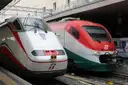 Two Italian intercity trains stand side by side at a station platform