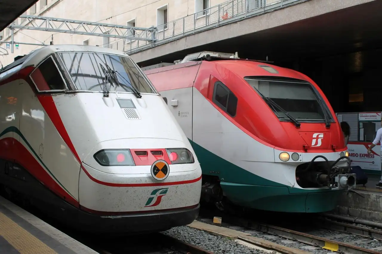 Two Italian intercity trains stand side by side at a station platform