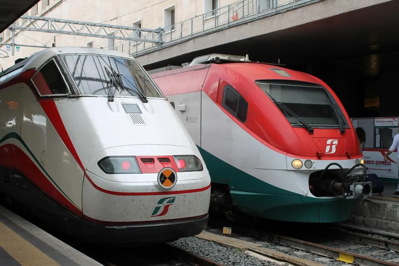 Two Italian intercity trains stand side by side at a station platform