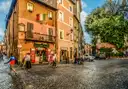 A cobbled street with cafes and old houses in Trastevere, Rome