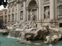 The Trevi Fountain with its statues and pool, seen from the front
