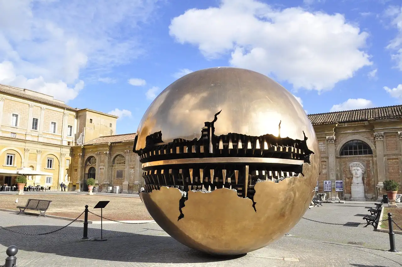 A large bronze sphere sculpture in a courtyard of the Vatican Museums