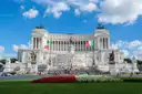 The white Vittoriano monument on Piazza Venezia in Rome, with flower beds in front